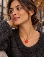 Woman wearing ar ed Tagua star pendant necklace on a fine gold-tone chain